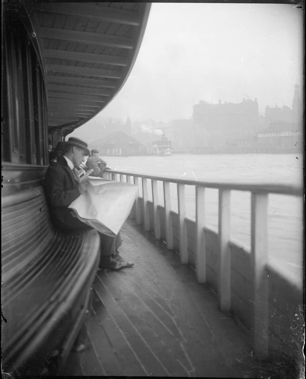 A man reads a newspaper on a ferry ride